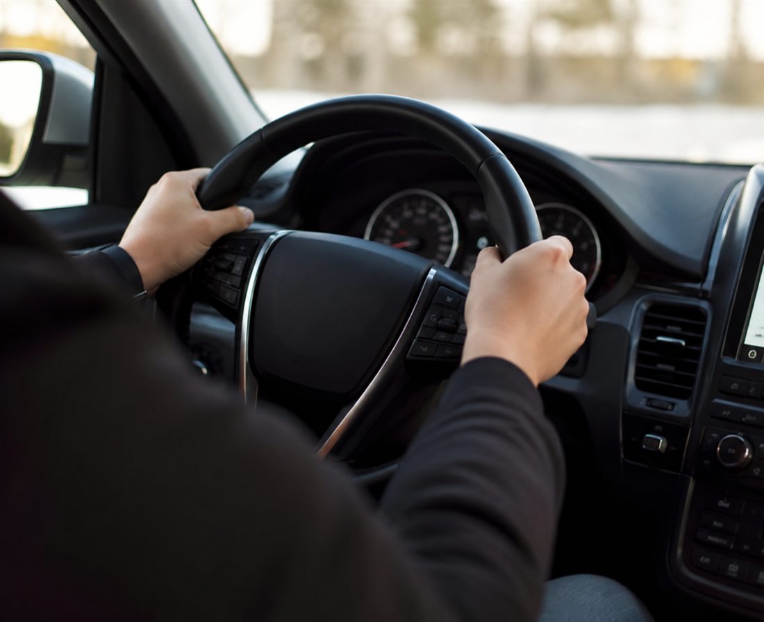 Persona conduciendo con las manos al volante, sin mostrar el rostro